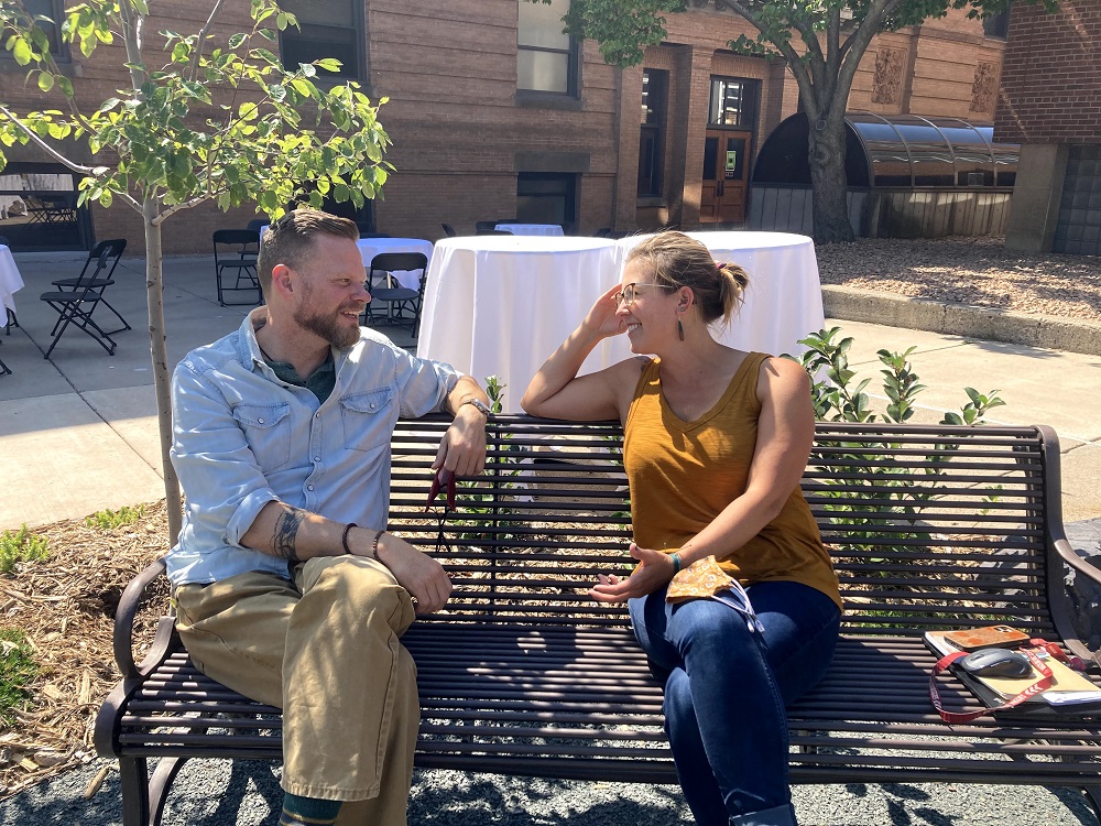 two people talking on an outdoor bench